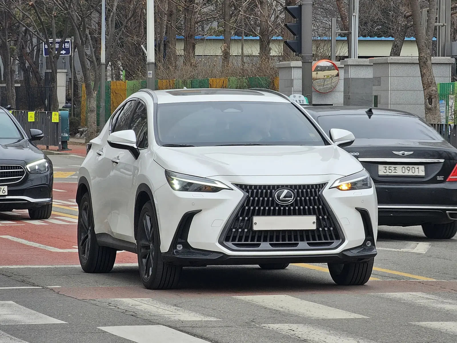 White Lexus NX 350h compact luxury hybrid SUV parked on a city street
