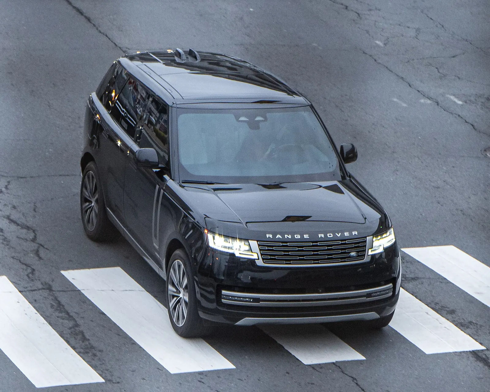 Black Range Rover full-size luxury SUV driving through a crosswalk, a frequent lease in Beverly Hills