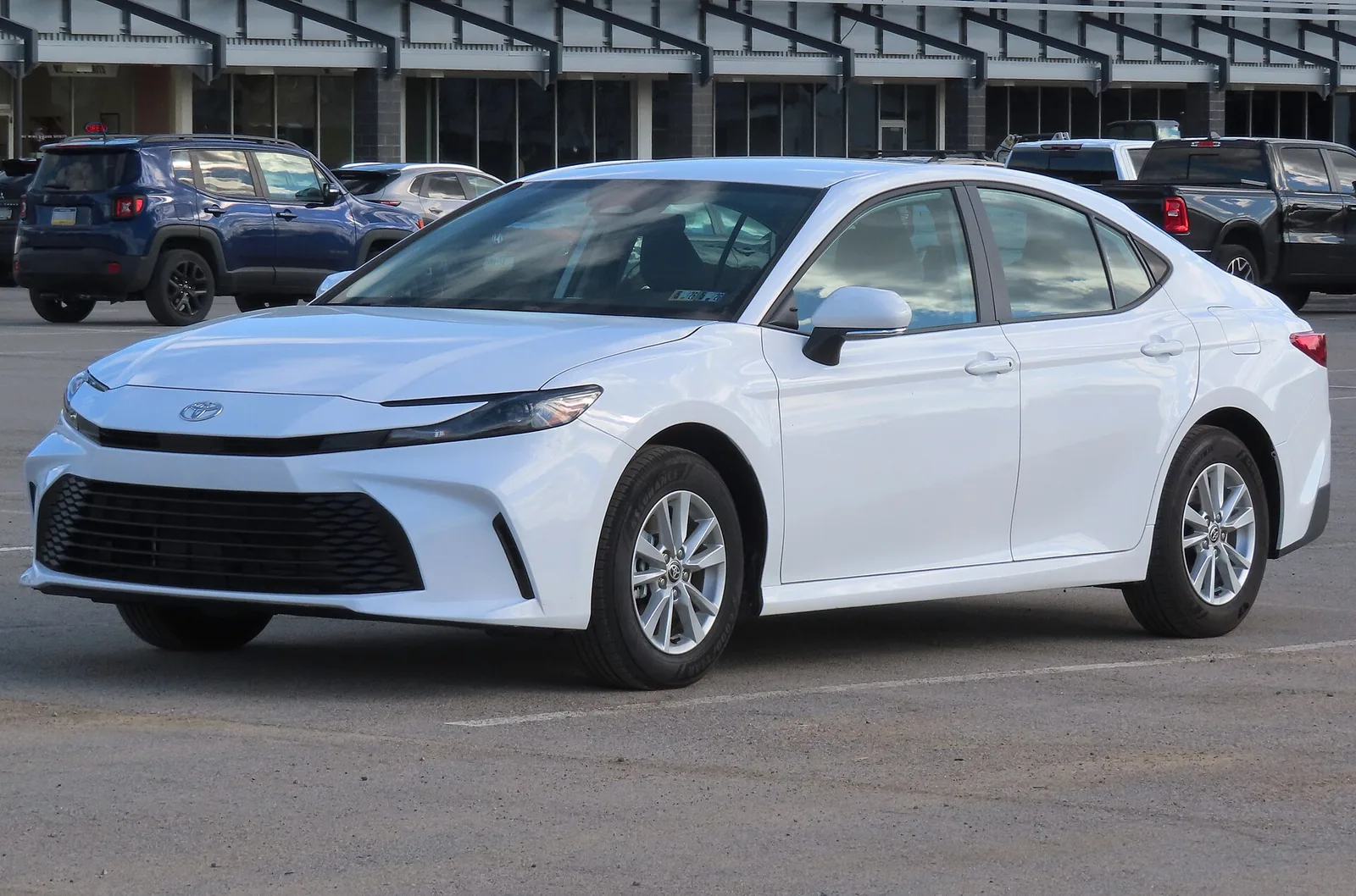 White Toyota Camry LE sedan, front three-quarter view, a popular commuter car in Long Beach